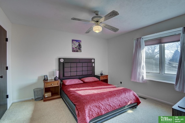 bedroom with baseboards, visible vents, and light carpet