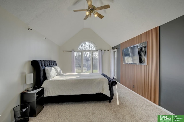 carpeted bedroom featuring wood walls, vaulted ceiling, and a ceiling fan