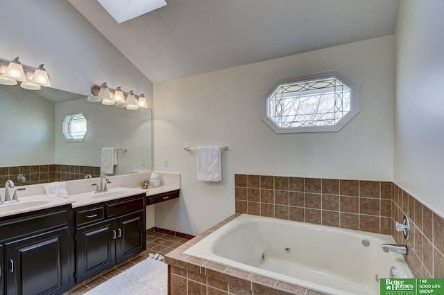 full bathroom featuring double vanity, a sink, a whirlpool tub, and vaulted ceiling with skylight
