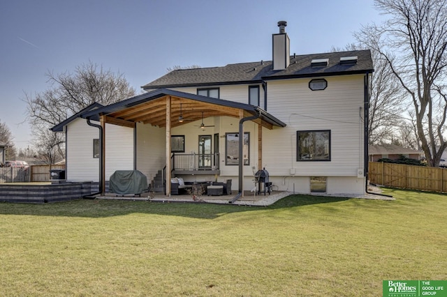 back of property with a patio, fence, and a yard