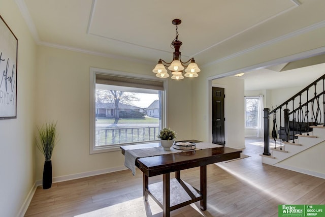dining room with a notable chandelier, crown molding, light wood-style flooring, and stairway