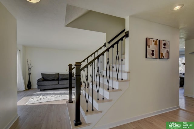 staircase with baseboards and wood finished floors