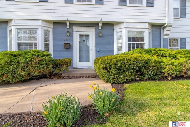 doorway to property with brick siding