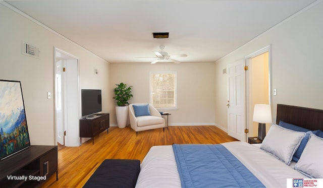 bedroom featuring light wood-type flooring, ceiling fan, crown molding, and visible vents