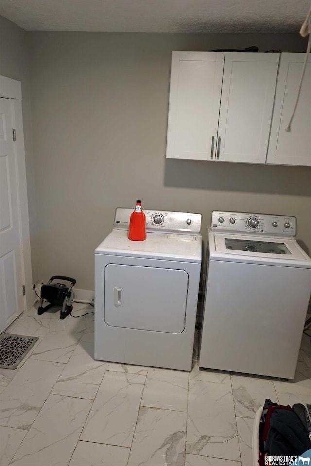laundry area featuring marble finish floor, cabinet space, baseboards, and washer and clothes dryer