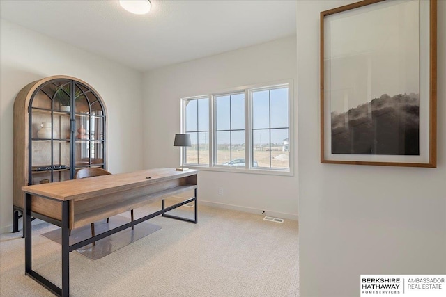 carpeted home office featuring baseboards and visible vents