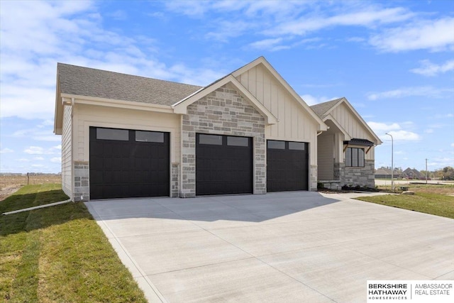 view of front of property with a garage, stone siding, a shingled roof, board and batten siding, and driveway