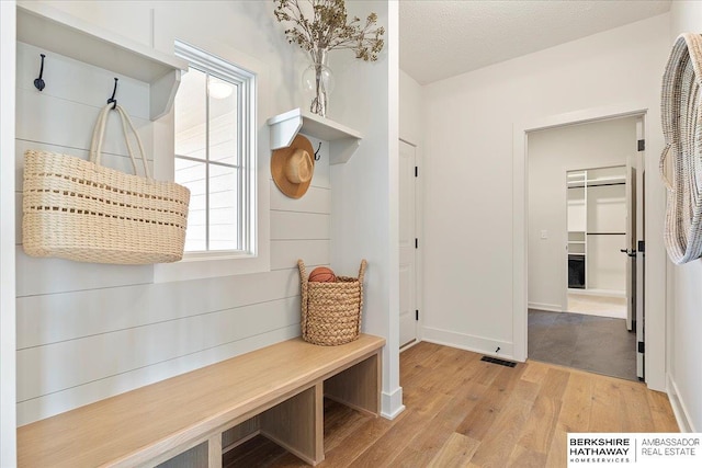 mudroom featuring baseboards, wood finished floors, and visible vents