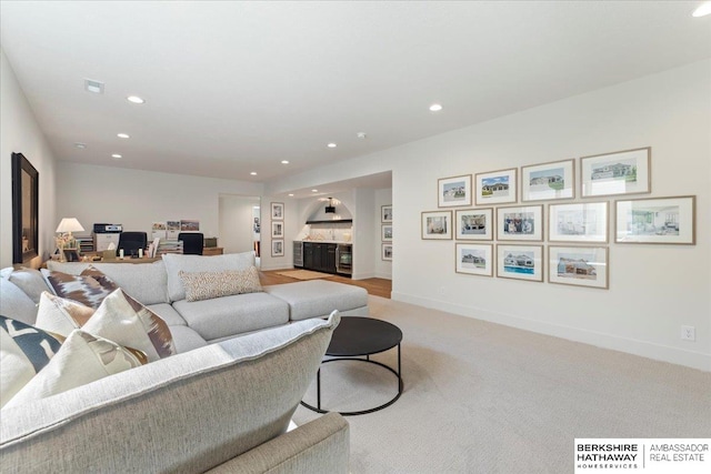 living area with baseboards, recessed lighting, and light colored carpet