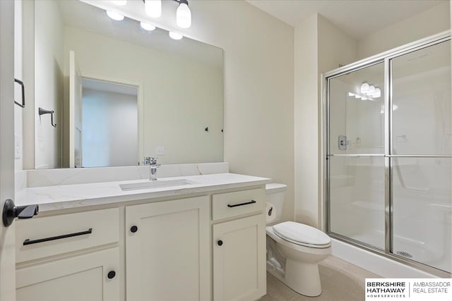 bathroom featuring vanity, toilet, and a stall shower