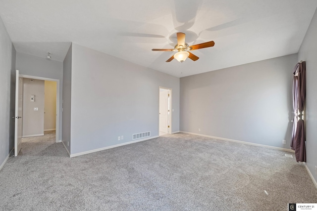 carpeted empty room featuring baseboards, ceiling fan, and visible vents