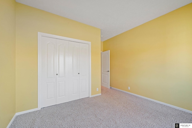 unfurnished bedroom with carpet flooring, a closet, and baseboards
