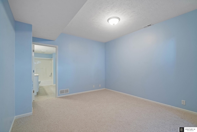 unfurnished bedroom featuring baseboards, a textured ceiling, visible vents, and carpet