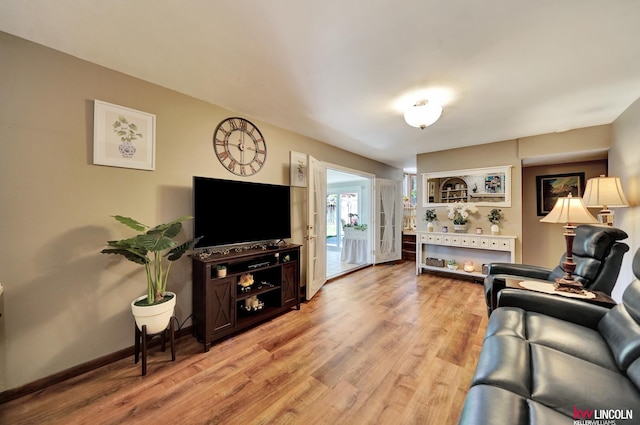 living room featuring light wood finished floors and baseboards
