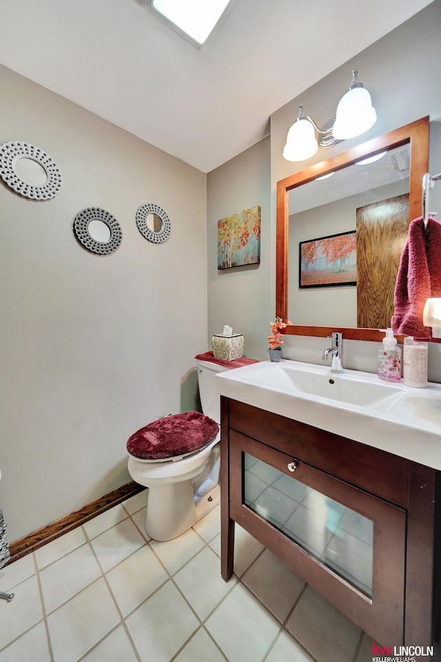 half bathroom featuring toilet, vanity, and tile patterned flooring