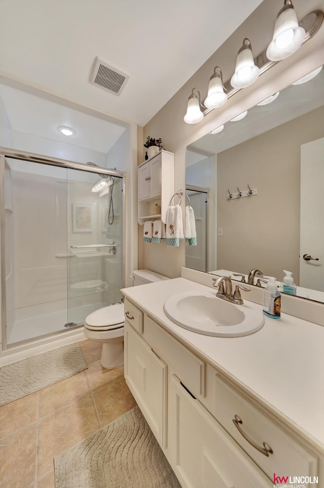 bathroom with a shower stall, vanity, toilet, and tile patterned floors