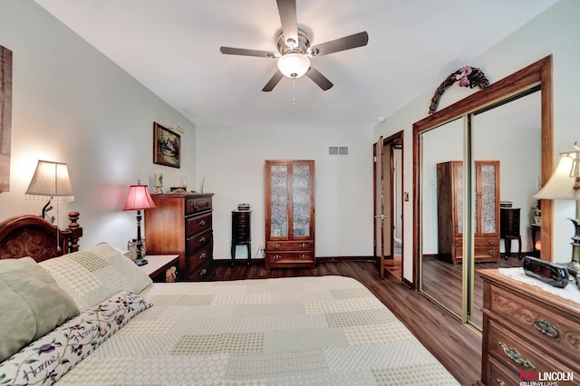 bedroom with dark wood-style floors, a closet, ceiling fan, and baseboards