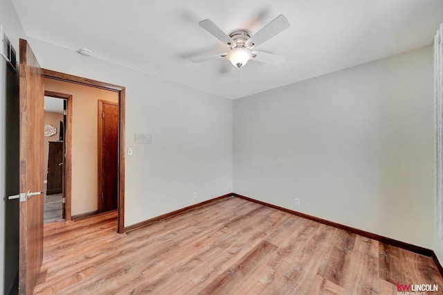 spare room with a ceiling fan, light wood-style flooring, baseboards, and a smoke detector