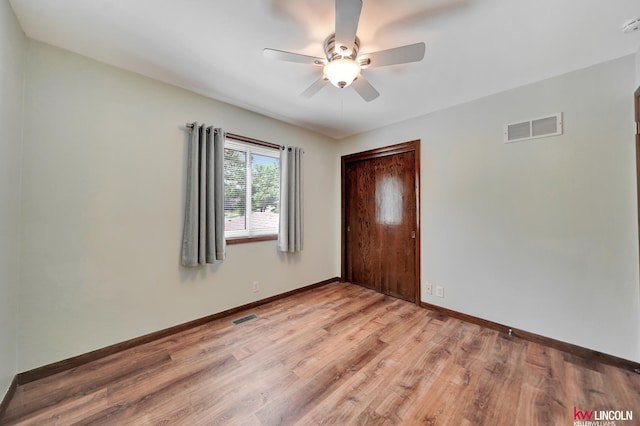 unfurnished bedroom with light wood-type flooring, a closet, baseboards, and ceiling fan