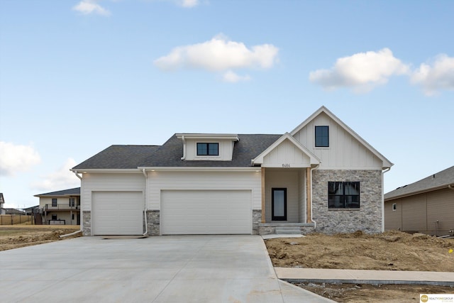 view of front of house featuring stone siding, an attached garage, board and batten siding, driveway, and a shingled roof