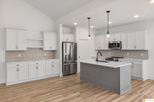 kitchen with light countertops, a sink, open shelves, stainless steel appliances, and white cabinets