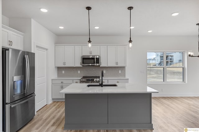 kitchen with light countertops, a sink, appliances with stainless steel finishes, and decorative backsplash