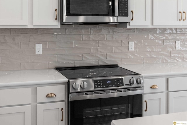 kitchen with white cabinetry, stainless steel appliances, and tasteful backsplash