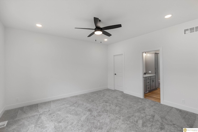 unfurnished bedroom featuring ensuite bathroom, visible vents, carpet, baseboards, and recessed lighting