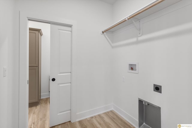clothes washing area with hookup for an electric dryer, hookup for a washing machine, baseboards, light wood-style flooring, and laundry area