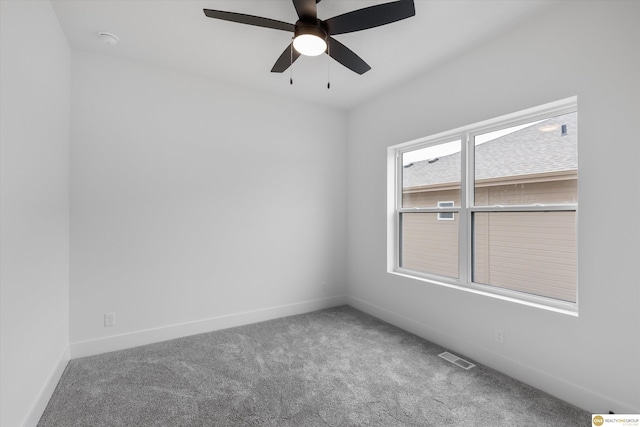 carpeted spare room featuring baseboards, visible vents, and a ceiling fan