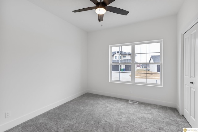 unfurnished bedroom featuring carpet flooring, baseboards, visible vents, a ceiling fan, and a closet