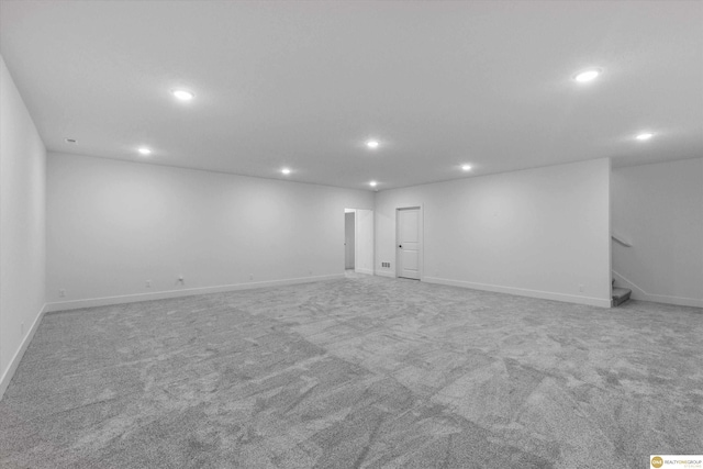 finished below grade area with carpet flooring, baseboards, recessed lighting, and stairway