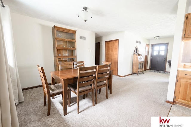dining room with visible vents, baseboards, and light carpet
