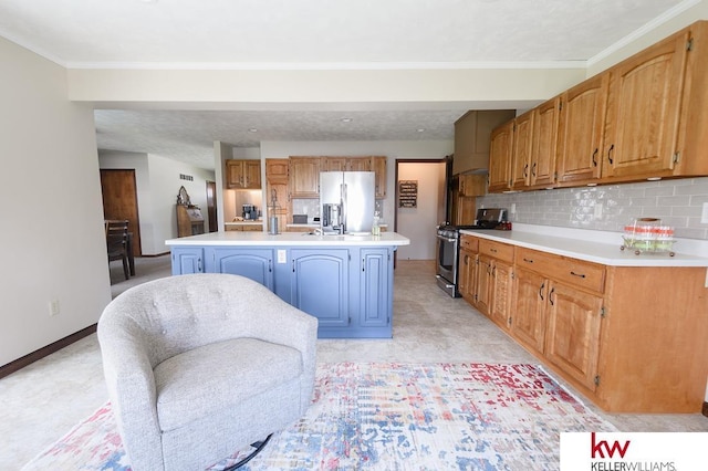 kitchen with baseboards, an island with sink, light countertops, decorative backsplash, and stainless steel appliances