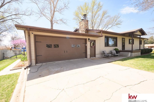 ranch-style home featuring concrete driveway, a chimney, a front lawn, an attached garage, and fence