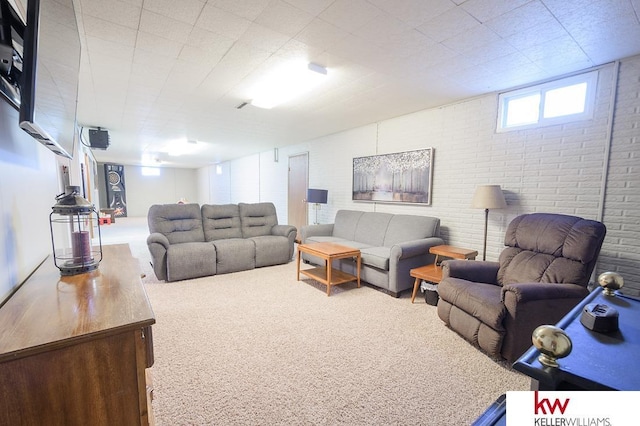 living area featuring brick wall and carpet