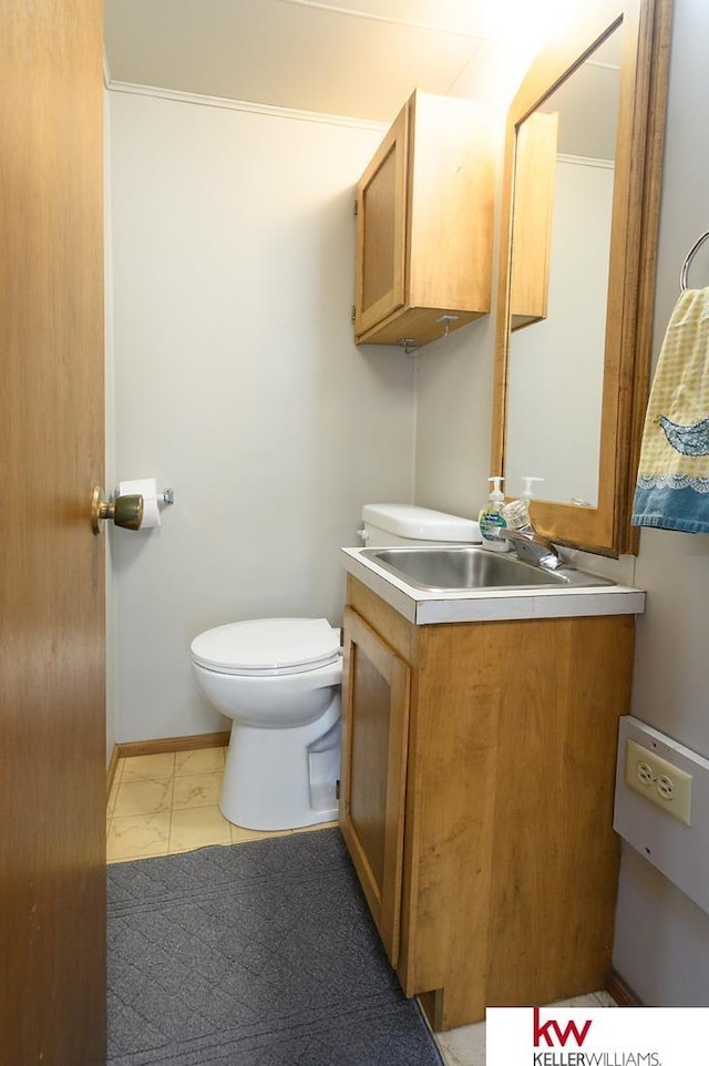 bathroom with marble finish floor, vanity, baseboards, and toilet