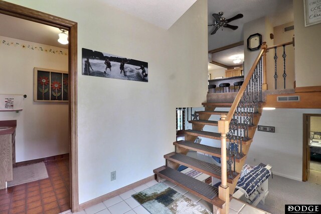 stairs with baseboards, ceiling fan, and visible vents