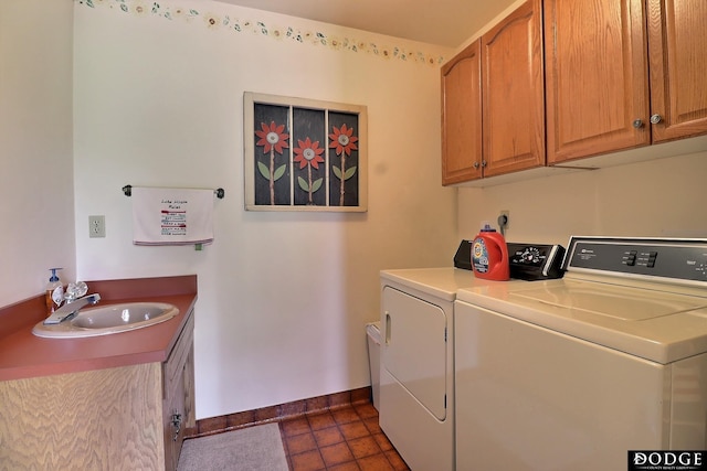 clothes washing area featuring a sink, separate washer and dryer, dark tile patterned floors, baseboards, and cabinet space