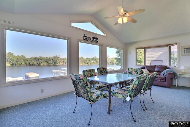 dining area featuring lofted ceiling, a water view, ceiling fan, and carpet