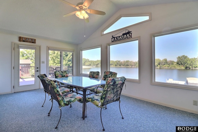 dining area featuring a water view, baseboards, a ceiling fan, carpet floors, and vaulted ceiling