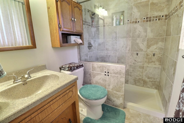 bathroom with toilet, vanity, and tiled shower