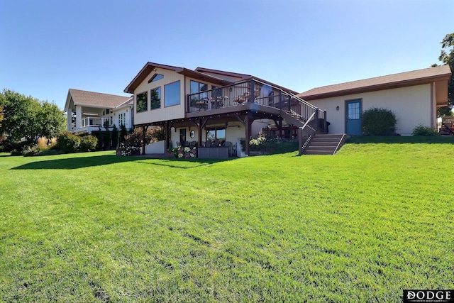 rear view of house featuring a yard, stairs, and a wooden deck