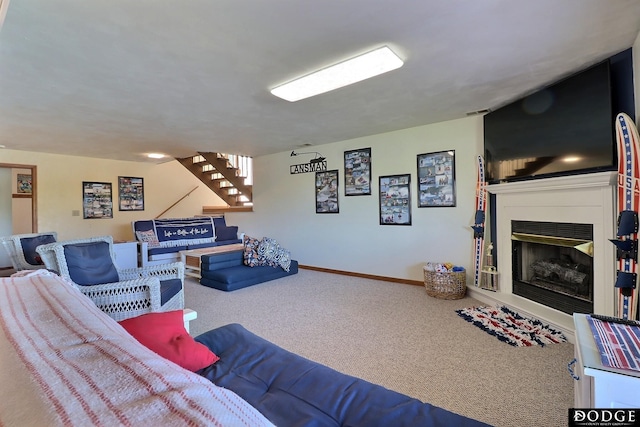 living room with baseboards, stairs, carpet flooring, and a glass covered fireplace