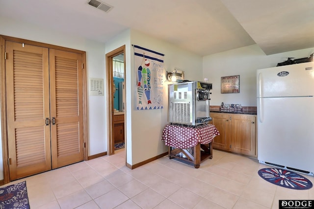 kitchen with visible vents, dark countertops, light tile patterned floors, and freestanding refrigerator