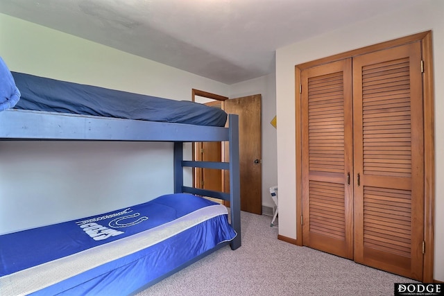 carpeted bedroom with baseboards and a closet