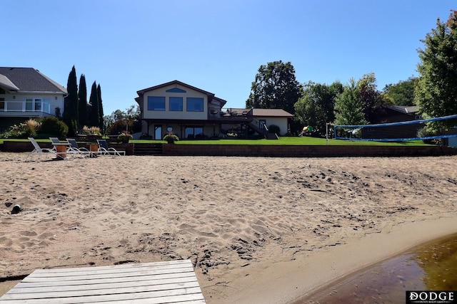 rear view of property with volleyball court