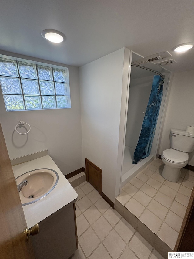1626 N C St, Fremont, NE 68025 - full bathroom with a stall shower, toilet, vanity, and tile patterned flooring