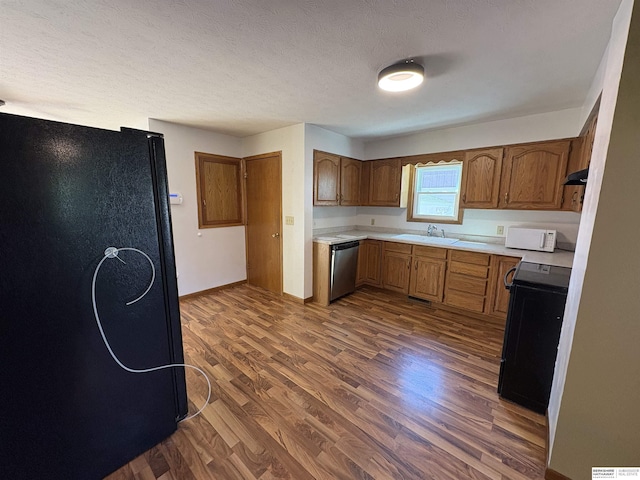 1626 N C St, Fremont, NE 68025 - kitchen featuring dishwasher, a sink, stove, light countertops, and dark wood-style floors