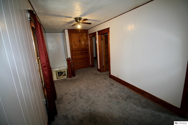 interior space featuring baseboards, a textured ceiling, carpet, and a ceiling fan